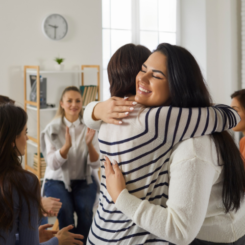 Happy Young Women Hugging Each Other in Women's Support Group Therapy Session
